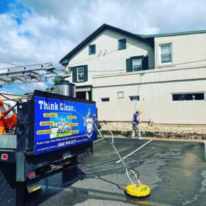 A truck with a sign promoting cleanliness, offering services like power washing, dryer vent cleaning, gutter cleaning, and snow removal.
